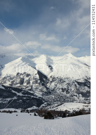 Small village nestled between enormous snowy mountains 114552431