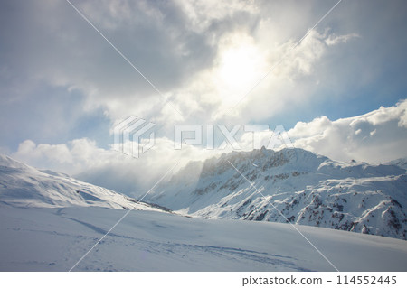Sunlight beams through snowy peaks of French Alps 114552445