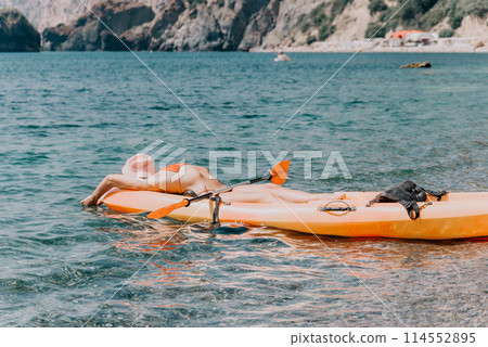 Woman sea kayak. Happy smiling woman paddling in kayak on ocean. Calm sea water and horizon in background. Active lifestyle at sea. Summer vacation. 114552895
