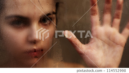 Woman touching steamy shower glass with hand 114552998