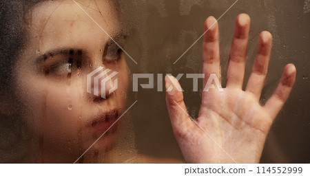 Woman touching steamy shower glass with hand Woman touching steamy shower glass with hand 114552999