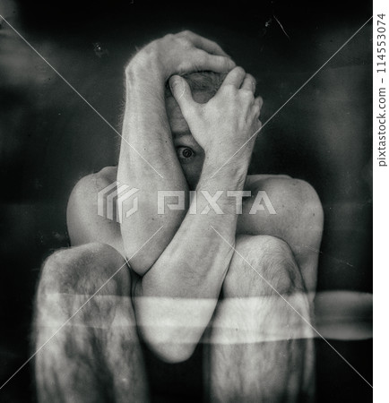 Man sitting in fear covering his face Man sitting in fear covering his face 114553074