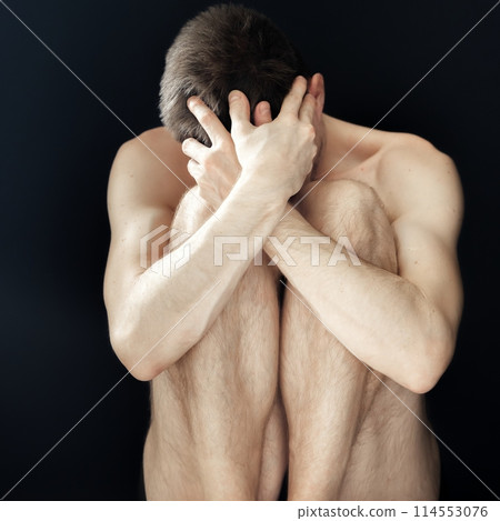 Man sitting in fear covering his face Man sitting in fear covering his face 114553076