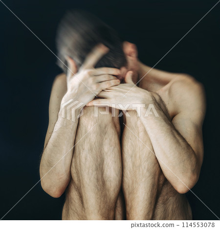 Man sitting in fear covering his face Man sitting in fear covering his face 114553078