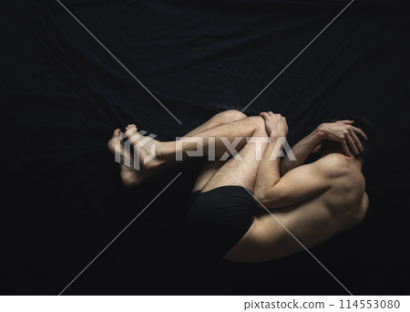 Man laying in fear, covering his face 114553080