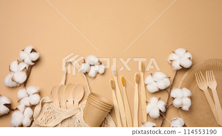 Cotton bag, wooden spoon, plates and cups on a brown background. Waste recycling concept, zero waste 114553190