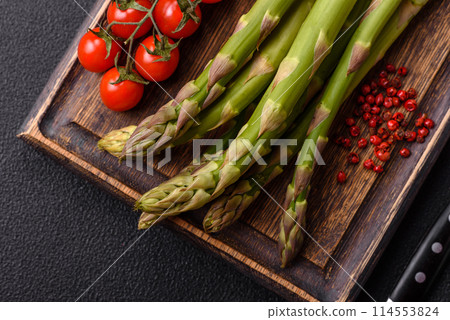 Sprigs of raw green asparagus as an ingredient for preparing a healthy breakfast 114553824