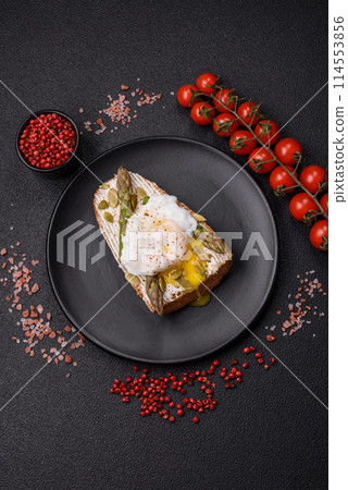 Delicious hearty breakfast consisting of poached eggs on toast with cream cheese, asparagus 114553856