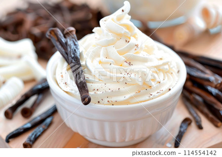 Vanilla ice cream with fluffy whipped cream and vanilla pods on wooden background 114554142