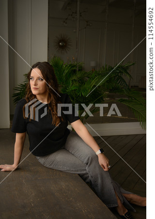 A psychologist girl in a business style poses in an interior photo studio. 114554692