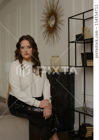 A psychologist girl in a business style poses in an interior photo studio. A psychologist girl in a business style poses in an interior photo studio. 114554711
