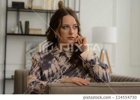 A psychologist girl in a business style poses in an interior photo studio. A psychologist girl in a business style poses in an interior photo studio. 114554730