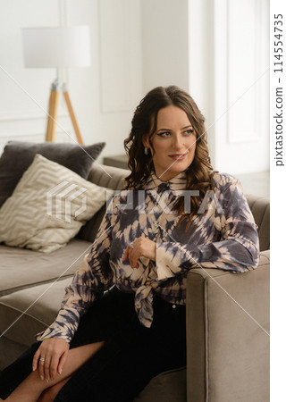 A psychologist girl in a business style poses in an interior photo studio. A psychologist girl in a business style poses in an interior photo studio. 114554735