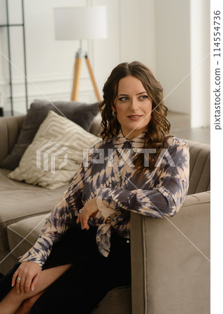 A psychologist girl in a business style poses in an interior photo studio. 114554736