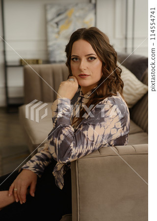 A psychologist girl in a business style poses in an interior photo studio. A psychologist girl in a business style poses in an interior photo studio. 114554741