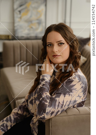 A psychologist girl in a business style poses in an interior photo studio. 114554742