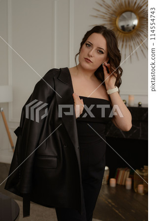 A psychologist girl in a business style poses in an interior photo studio. 114554743