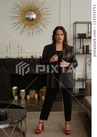 A psychologist girl in a business style poses in an interior photo studio. 114554751