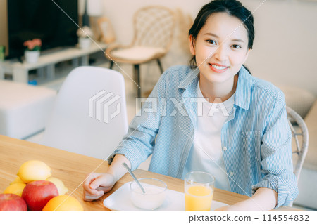 Young woman eating yogurt 114554832