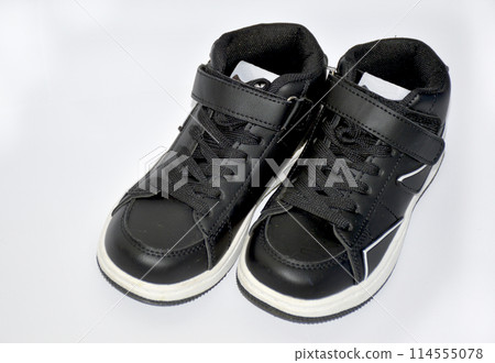 children's sneakers in black with a white stripe on the sole on white background children's sneakers in black with a white stripe on the sole on white background 114555078