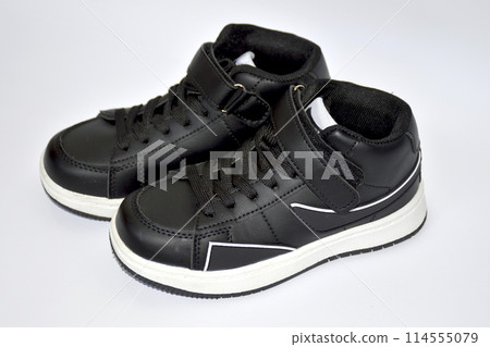 children's sneakers in black with a white stripe on the sole on white background children's sneakers in black with a white stripe on the sole on white background 114555079