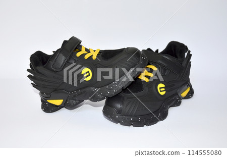 children's sneakers in black with yellow laces on a white background children's sneakers in black with yellow laces on a white background 114555080