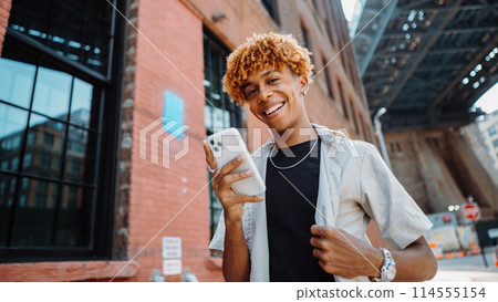 Watch the young man smiling in front of the real estate building facade Watch the young man smiling in front of the real estate building facade 114555154
