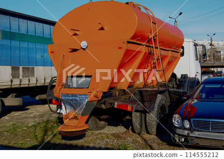 Special road equipment.A bright orange truck for spreading sand or salt on the road. Special road equipment.A bright orange truck for spreading sand or salt on the road. 114555212