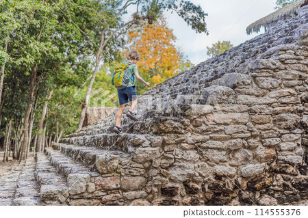 Boy tourist at Coba, Mexico. Ancient mayan city in Mexico. Coba is an archaeological area and a famous landmark of Yucatan Peninsula. Cloudy sky over a pyramid in Mexico 114555376
