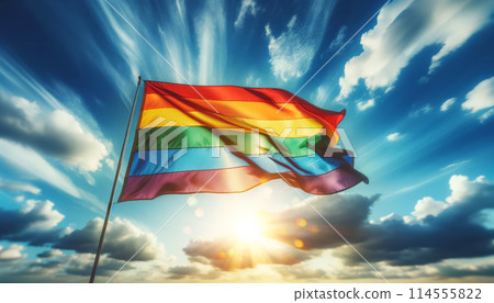Rainbow flag waving in sky, illuminated by sunlight, symbolizing freedom, pride, LGBTQ community 114555822