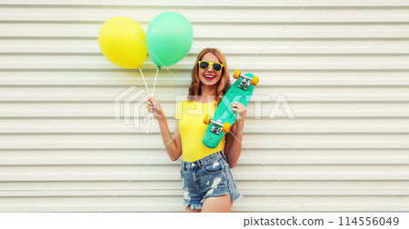 Summer, holiday, celebration, happy cheerful young woman with bright colorful balloons, skateboard Summer, holiday, celebration, happy cheerful young woman with bright colorful balloons, skateboard 114556049