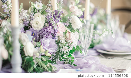 Wedding table decoration with lavender flowers, sweets, cake and candles Wedding table decoration with lavender flowers, sweets, cake and candles 114556808