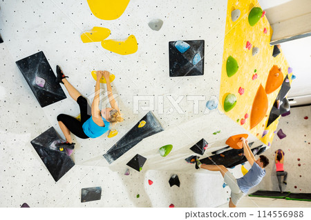 Climbing training on an artificial climbing wall indoor 114556988