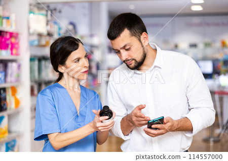 Woman with smartphone having conversation with female apothecary Woman with smartphone having conversation with female apothecary 114557000
