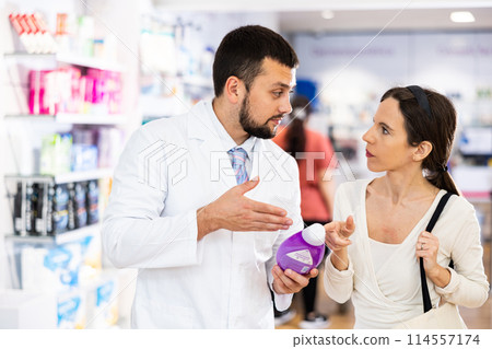 Male pharmacist advising woman customer in drugstore Male pharmacist advising woman customer in drugstore 114557174