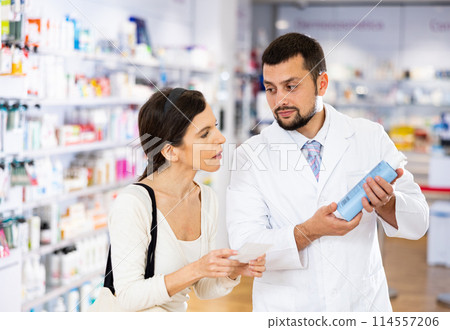 Pharmacist consulting woman buyer about hair care product Pharmacist consulting woman buyer about hair care product 114557206