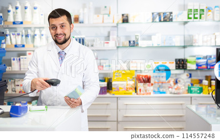 Friendly man pharmacist working at cash desk 114557248
