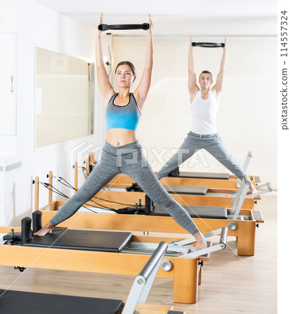 Girl performing pilates exercises with flex ring on reformer Girl performing pilates exercises with flex ring on reformer 114557324
