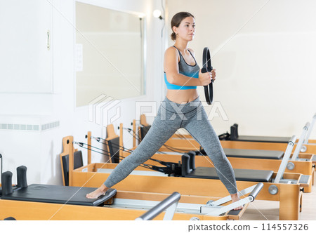Girl restores her health with the help of gymnastic ring during Pilates classes Girl restores her health with the help of gymnastic ring during Pilates classes 114557326