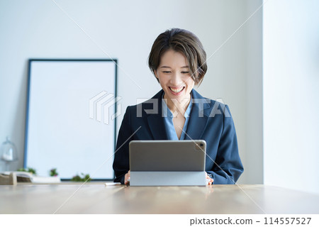 一個穿著西裝的女人在房間裡工作 114557527