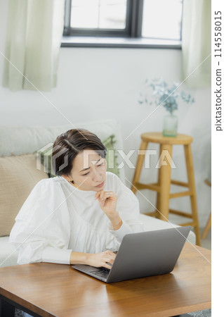 在客廳裡使用電腦的中年女人 114558015