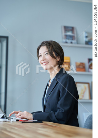 一個穿著西裝的女人坐在平板電腦前 一個穿著西裝的女人坐在平板電腦前 114559364