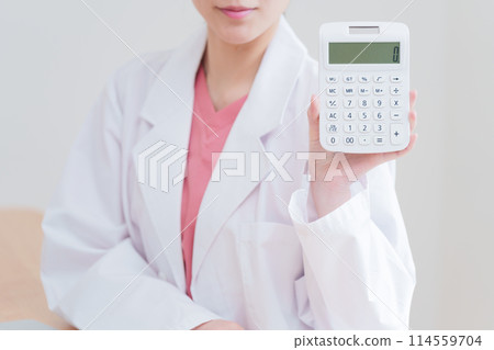 Female doctor calculating with a calculator Female doctor calculating with a calculator 114559704