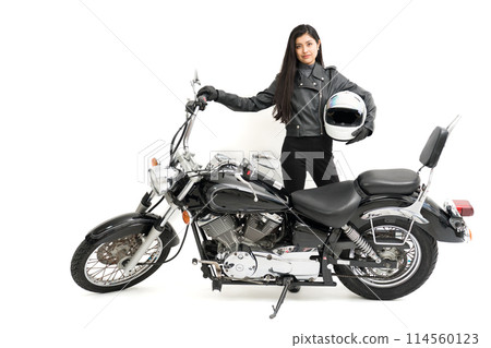 A biker girl standing next to her bike with a helmet A biker girl standing next to her bike with a helmet 114560123