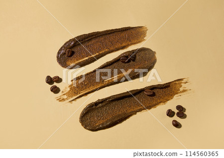 Creative design template with dark brown exfoliation smudges has coffee origin decorated against light brown flat, coffee beans scattered around. Copy space for text, high angle shot 114560365