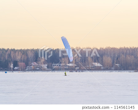 Kite surfer ride on snowboard. Snowkiting in the snow on frozen lake. Kite surfer ride on snowboard. Snowkiting in the snow on frozen lake. 114561145