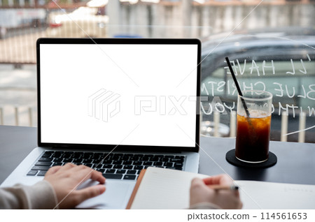 A close-up image of a college student studying online on her laptop computer at a coffee shop. 114561653