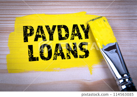 PAYDAY LOANS. Yellow paint and paint brush on wooden texture background 114563085