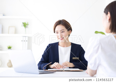 Business woman in a suit serving customers Business woman in a suit serving customers 114563227