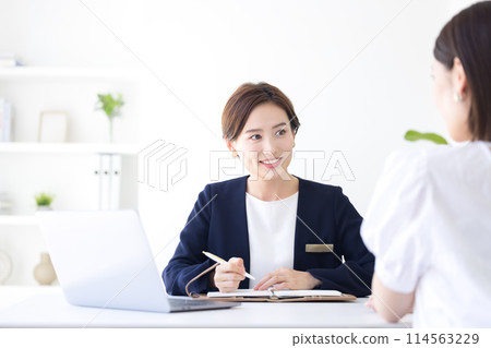 Business woman in a suit serving customers 114563229